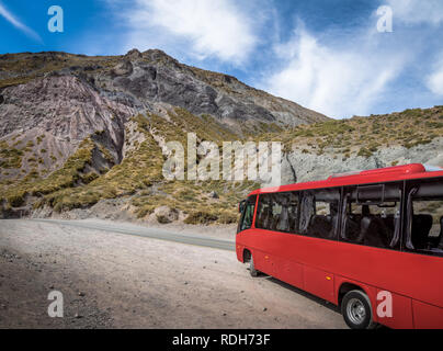 Red Bus auf einer Straße am Cajon del Maipo Canyon - Chile Stockfoto