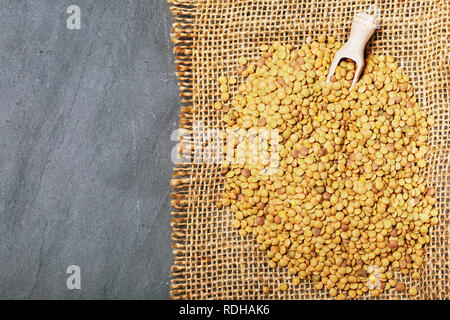 Roh Linsen auf Schwarz Stein Hintergrund. Gesunde vegetarische Essen Konzept. Superfoods. Ansicht von oben, kopieren. Linsen sind reich an komplexen Kohlenhydraten, f Stockfoto