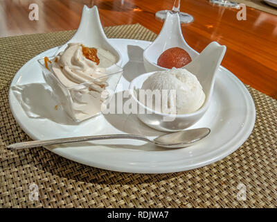 Indische Spezialitäten gulab jamun, rasgulla, payesh und Sahne in Stil auf einem Holztisch servered Stockfoto