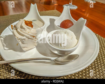 Indische Spezialitäten gulab jamun, rasgulla, payesh und Sahne in Stil auf einem Holztisch servered Stockfoto