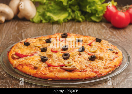 Seitenansicht der Pizza mit Speck, Schinken, Oliven und Champignons Stockfoto