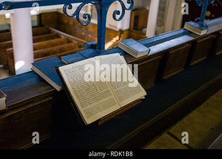 Ein jüdisches Gebet Buch öffnen auf einer Bank in einer Synagoge im East End von London, von anderen Gebet Bücher umgeben, die eine Seite in Hebräisch Stockfoto