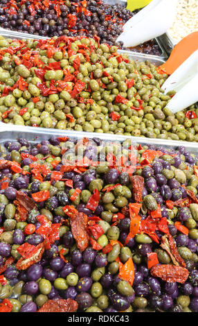 Fach mit schwarze und grüne Oliven mit Paprika gefüllt zum Verkauf in der Marktstand eines mediterranen Land Stockfoto