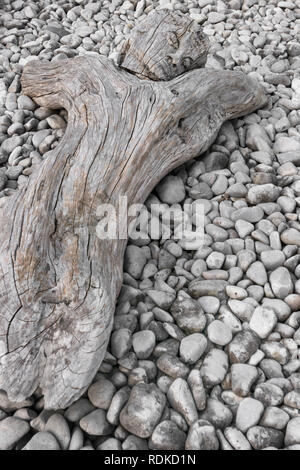 Holz geschnitzte Statue des gekreuzigten Jesus Christus. Seltsame Künstlerische Statue. Die Skulptur liegt auf weißen Kieselsteinen. Stockfoto