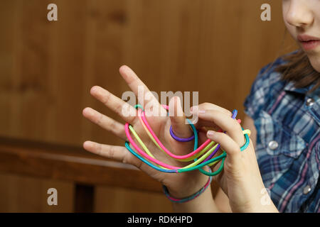 Kind spielen Classic, old-school string Spiel und didaktisches Spielzeug mit den Fingern, Erzeugen von Formen, ihre motorischen Fähigkeiten zu entwickeln. IQ, Bildung, intellig Stockfoto