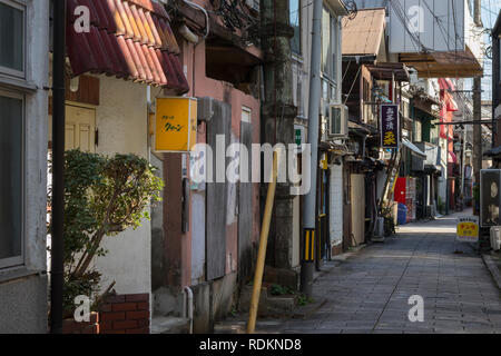 Beppu, Japan - November 3, 2018: Kleine Straße in der Mitte der Stadt von Beppu mit Zeichen und viel Strom Kabel Stockfoto