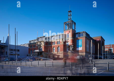 Kiel, Deutschland - 18. Januar 2019: Kieler Hauptbahnhof, Menschen, die sich in den Vordergrund zu Überqueren der Straße Stockfoto