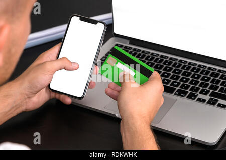 Junge Geschäftsmann der Eingabe der Kreditkartendaten auf einer PC-Tastatur. Kreditkarte in der Hand sichtbar. Close Up, Business Office Arbeitsplatz. Schulden, wobei b Stockfoto