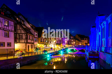 Alten bunten Häuser beleuchtet, kleiner Fluss, Wasser Reflexion in der Nacht im Frühling, Colmar, Frankreich. Stockfoto