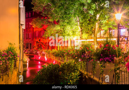 Alten bunten Häuser beleuchtet, kleiner Fluss, Wasser Reflexion in der Nacht im Frühling, Colmar, Frankreich. Stockfoto