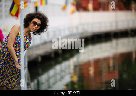 Asiatische Frau Sonnenbrille tragen am Ufer des Flusses. Stockfoto