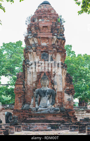 Wat Phra Mahathat (mahatat) in Ayutthaya, Thailand. Vertikale Foto. Brick Ruinen eines Turmes und ein Buddha Statue einer alten buddhistischen Tempel Stockfoto