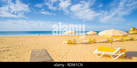 Schirme und Liegen am einsamen Strand in der Vorsaison Stockfoto