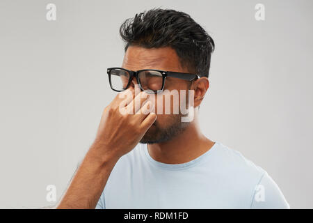 Müde Inder in Gläsern reibt Nasenbügel Stockfoto