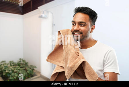 Lächelnd indischen Mann mit Handtuch über Dusche Stockfoto