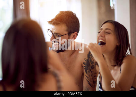 Glücklich der Mann und die Frau ihre Zähne putzen im Bad. Stockfoto
