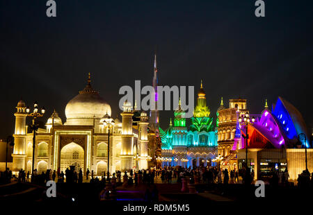 Bunt beleuchtete Global Village mit Masse Silhouette in Dubai, UAE. Ausführliche Pavillon Fassaden mit Touristen Stockfoto