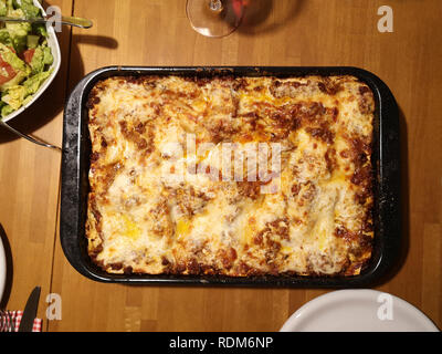 Lasagne mit Salat Stockfoto