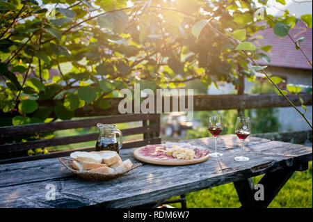 Outdoor Snack Time, Fleisch, Brot, Käse und Rotwein Stockfoto