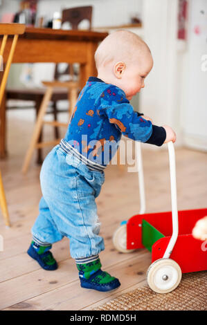 Baby Boy drücken Holz- Warenkorb Stockfoto