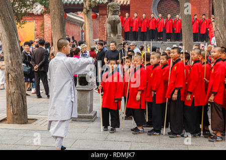 Dengfeng, China - Oktober 16, 2018: Schüler der Martial Arts School stand mit Polen und an ihre Lehrer. Shaolin Tempel. Stockfoto