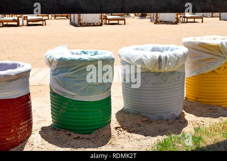 Vier Farben der Abfallbehälter am Strand, Rot, Grün, Weiß und Gelb Müllcontainer Stockfoto