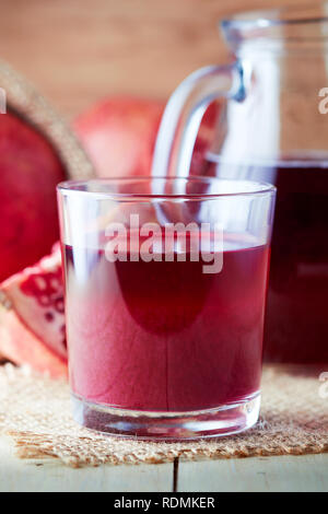 Frischen Granatapfelsaft in einem Glas auf Holz- Hintergrund Stockfoto