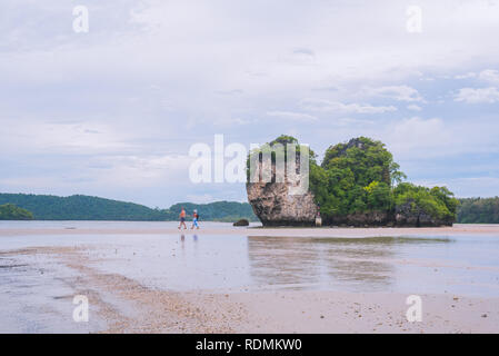 Ao Nang/Krabi, Thailand - Juli 2, 2018: Ein reifer Mann und eine asiatische Frau Spaziergang entlang den Had Noppharat Thara Beach während der Ebbe. Stockfoto