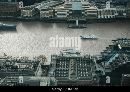 London, UK, 13. Januar 2019: City Cruise Boote auf der Themse, Ansicht von oben. Fluss Kreuzfahrten sind sehr beliebt bei Touristen das ganze Jahr über. Stockfoto