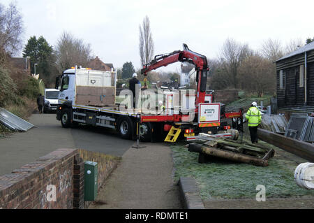 Flaches Bett Lkw mit hydraulischen Arm Hebezeuge Arbeiten zum Austausch der Schleuse Tore mit Arbeitern, Stourbridge Canal, West Mids, England, Großbritannien im Winter Stockfoto