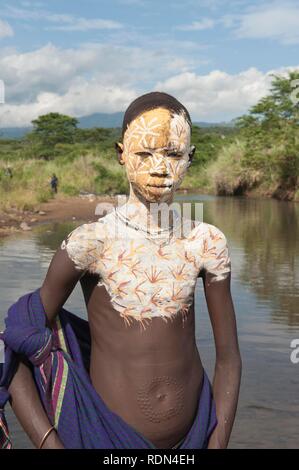 Surma Junge mit Gesichts- und Körperbemalung im Fluss, Kibish, Omo-tal, Äthiopien, Afrika Stockfoto