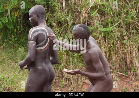 Vor dem Donga stick kämpfen, die surma Krieger ein Body Paint aus Lehm und Mineralien auf ihren Körpern anwenden, surma Stamm Stockfoto