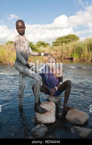 Zwei Surma Männer mit Gesichts- und Körperanwendungen Gemälde im Fluss, Kibish, Omo-tal, Äthiopien, Afrika Stockfoto