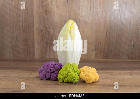 Endivie (cichorium endivie) und decoratif Blumenkohl auf natürlichen Holz- Hintergrund mit markieren und Schatten Stockfoto