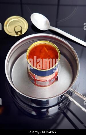 Nacherwärmung ein fertiggericht in eine Blechdose im Wasserbad, Gulaschsuppe Stockfoto