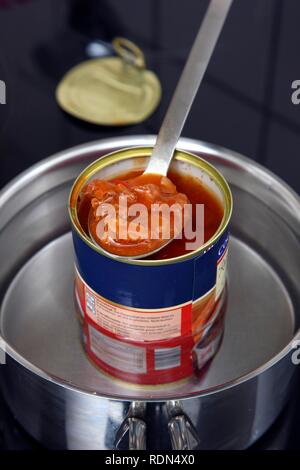 Nacherwärmung ein fertiggericht in eine Blechdose im Wasserbad, Gulaschsuppe Stockfoto