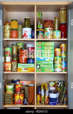 Schrank mit verschiedenen verpackten Lebensmitteln in Gläsern und Dosen gefüllt Stockfoto