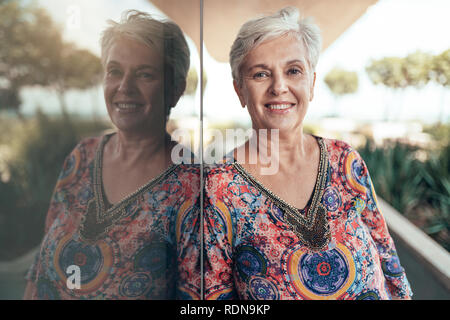Porträt einer schönen grauen Haaren middel gealterte Frau in die Kamera schaut Stockfoto