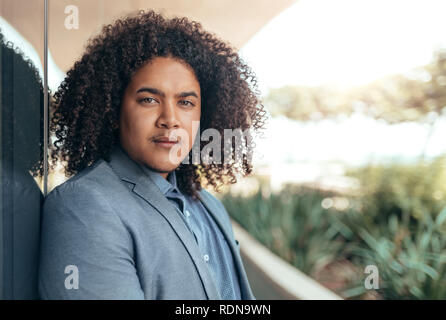 Jungen gemischten Rennen Kerl mit lockiges Afro-Haar seidig schauen in die Kamera Stockfoto