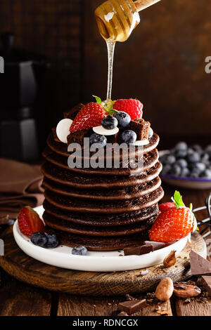 Stapel von Schokolade Pfannkuchen mit Beeren, Erdbeere, Himbeere und Heidelbeere Stockfoto