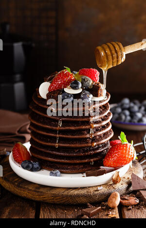 Stapel von Schokolade Pfannkuchen mit Beeren, Erdbeere, Himbeere und Heidelbeere Stockfoto