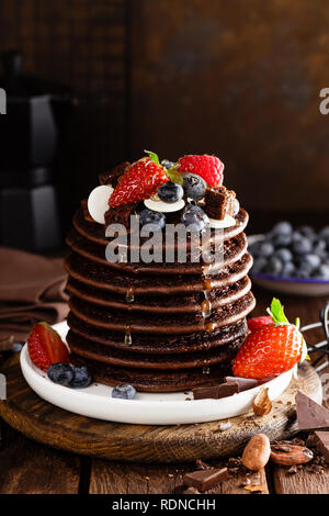 Stapel von Schokolade Pfannkuchen mit Beeren, Erdbeere, Himbeere und Heidelbeere Stockfoto