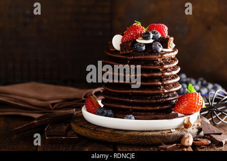 Stapel von Schokolade Pfannkuchen mit Beeren, Erdbeere, Himbeere und Heidelbeere Stockfoto