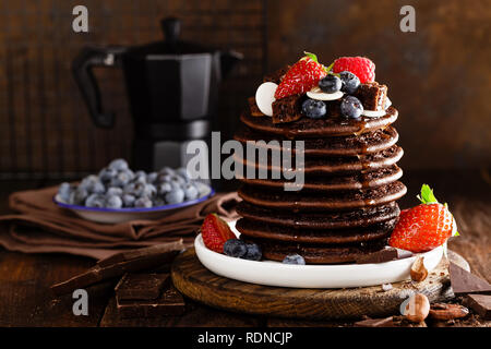 Stapel von Schokolade Pfannkuchen mit Beeren, Erdbeere, Himbeere und Heidelbeere Stockfoto