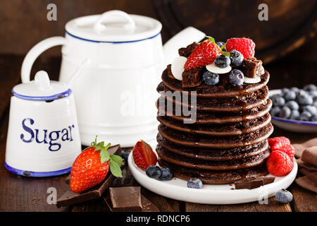 Stapel von Schokolade Pfannkuchen mit Beeren, Erdbeere, Himbeere und Heidelbeere Stockfoto