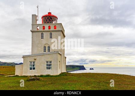 Leuchtturm am Kap Dyrhólaey, Dyrholaey, nächsten Reynisdrangar, felsnadeln vor der Küste von Vík Vík í Mýrdal, Stockfoto