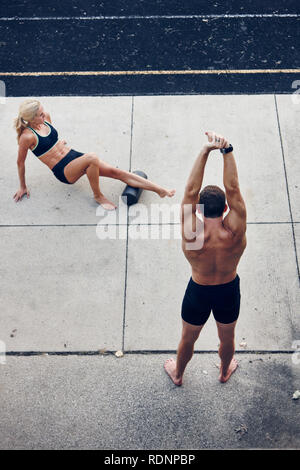 Athleten stretching bei Stadion Stockfoto