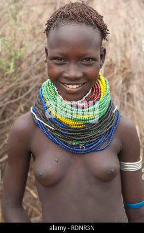 Nyangatom, bume oder Buma Mädchen mit perlenketten vor ihrer Hütte, Omo Valley, Äthiopien, Afrika Stockfoto