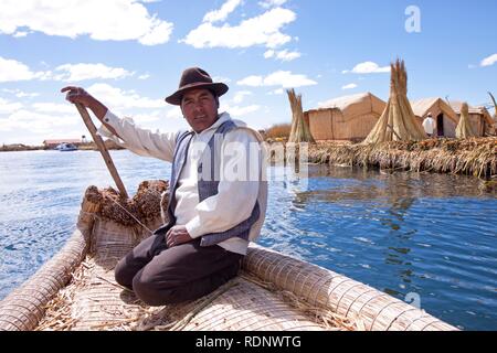 Mann Lenkung ein Rohr, Boot, schwebenden Uro Insel, Titicacasee, Puno, Peru, Südamerika Stockfoto