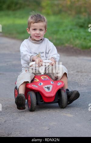 Little Boy fahren ein bobby-car Stockfoto